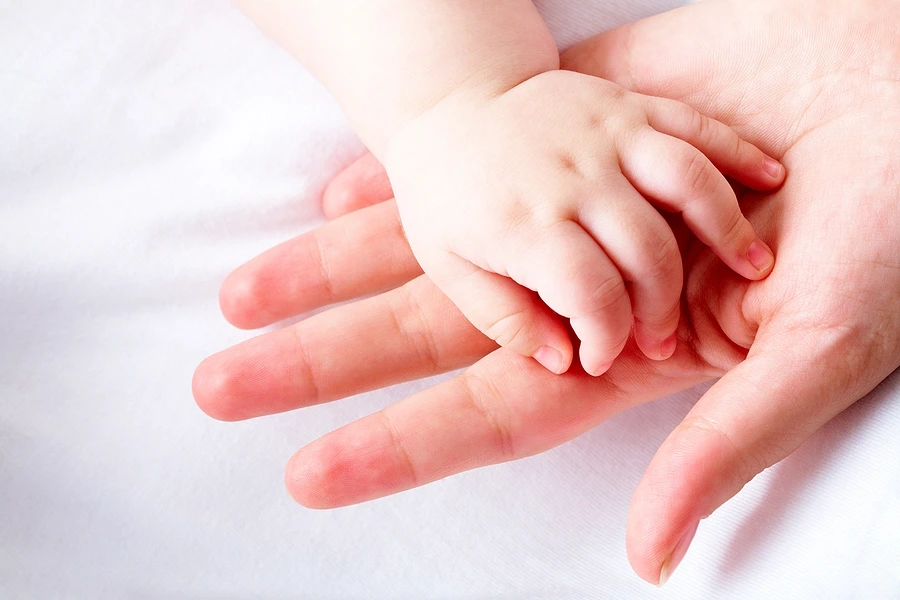 Baby_s hand in adult_s hand