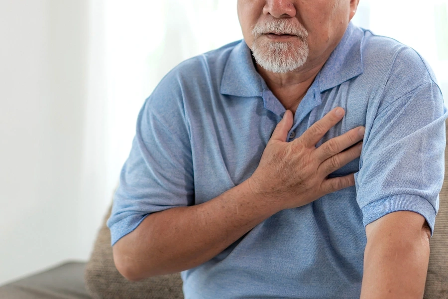 Senior male clutching chest
